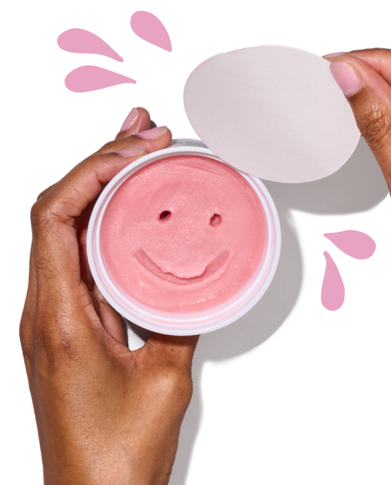Two hands opening the lid on a LUIGI'S Real Italian Ice. The Italian ice is pink with a smiley face carved in it. Pink splash graphics around. the cup.